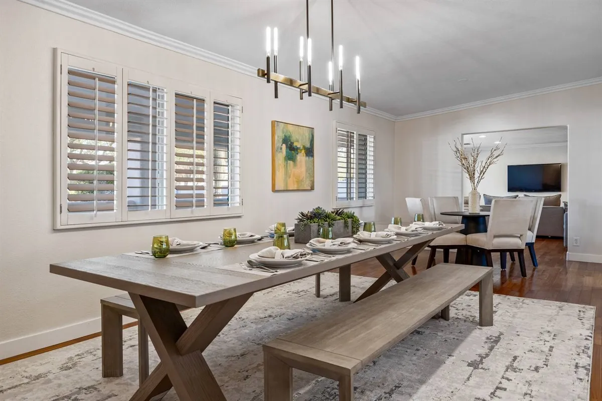 Long dining table with bench seating and upholstered chairs at Presidio Retreat.